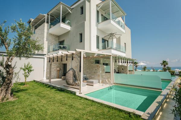 Τρίκλινο δωμάτιο με προσωπική πισίνα. Διατίθενται ξαπλώστρες και πολυθρόνες με θέα τον κήπο και την πισίνα.